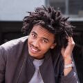 Smiling young man with afro touching hair