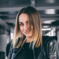 Young woman smirking in leather jacket