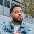 Bearded man wearing denim jacket looking upward